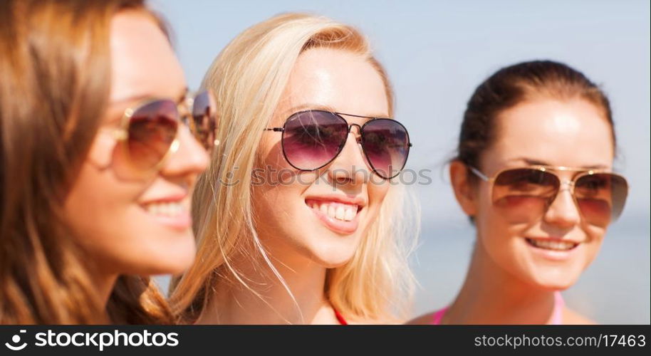 summer vacation, holidays, friendship and people concept - close up of smiling young women in sunglasses