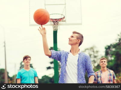 summer vacation, holidays, games and friendship concept - group of smiling teenagers playing basketball outdoors