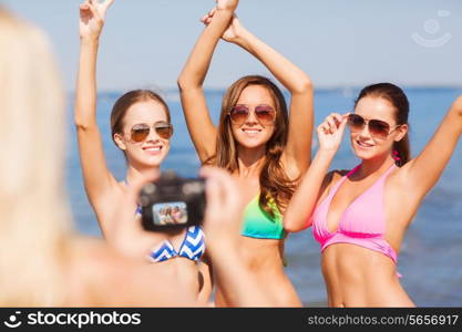 summer vacation, holidays, gesture and people concept - group of smiling women photographing by camera and showing peace sigh on beach