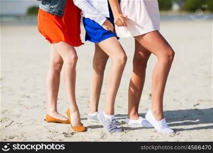 summer vacation, holidays, suntan, epilation and people concept - close up of women legs posing on beach