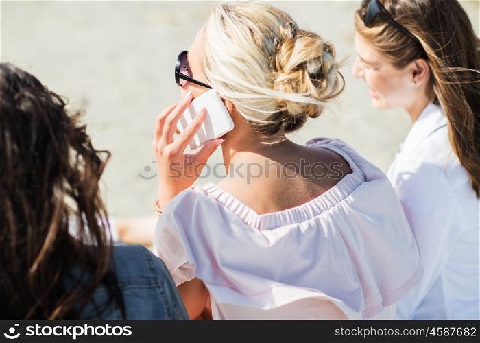 summer vacation, holidays, technology, travel and people concept - close up of young woman calling smartphone on beach