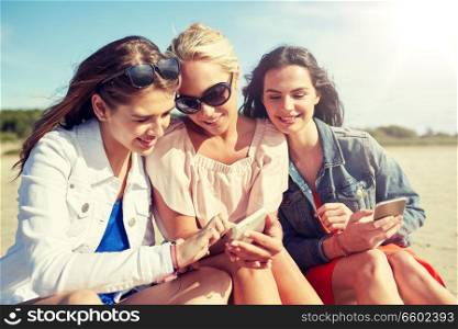 summer vacation, holidays, technology, travel and people concept - group of happy young women with smartphones on beach. group of happy women with smartphones on beach