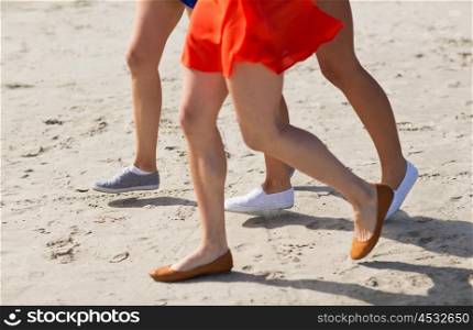 summer vacation, holidays, travel and people concept - close up of women legs running on beach