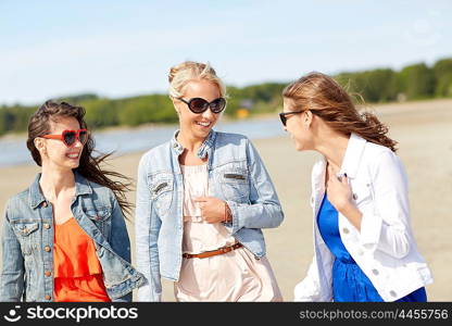 summer vacation, holidays, travel and people concept - group of smiling young women in sunglasses and casual clothes on beach