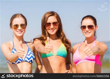 summer vacation, holidays, travel and people concept - group of smiling young women showing thumbs up on beach