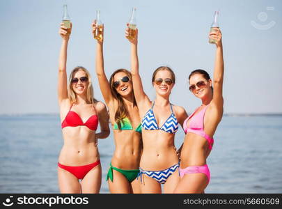 summer vacation, holidays, travel and people concept - group of smiling young women sunbathing and drinking on beach