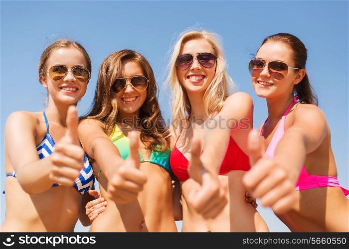 summer vacation, holidays, travel and people concept - group of smiling young women showing thumbs up over blue sky background