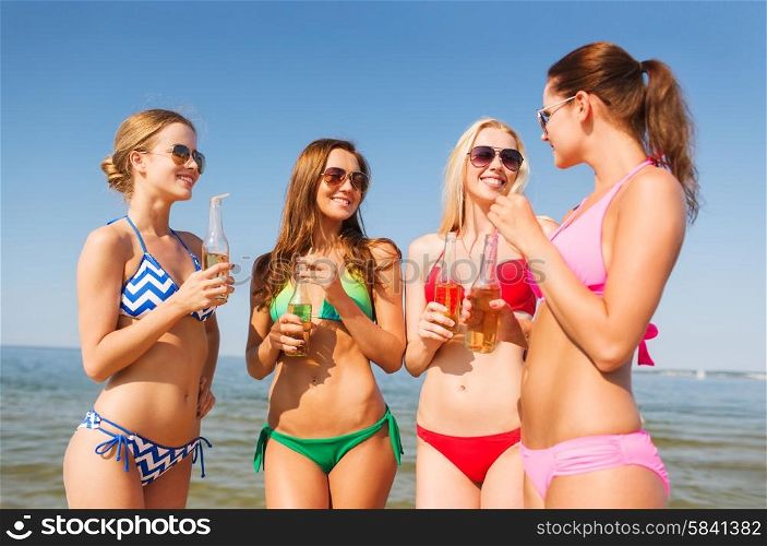 summer vacation, holidays, travel and people concept - group of smiling young women sunbathing and drinking on beach