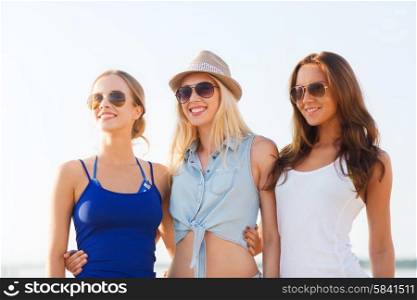 summer vacation, holidays, travel and people concept - group of smiling young women in sunglasses and casual clothes on beach