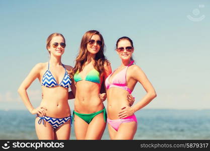 summer vacation, holidays, travel and people concept - group of smiling young women on beach