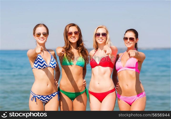 summer vacation, holidays, travel, gesture and people concept - group of smiling young women pointing finger on you on beach