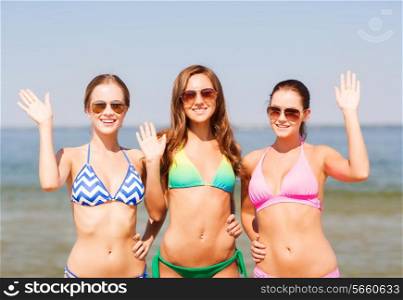 summer vacation, holidays, travel, gesture and people concept - group of smiling young women waving hands on beach