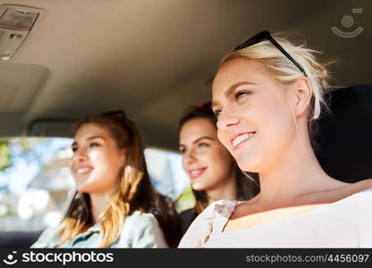 summer vacation, holidays, travel, road trip and people concept - happy teenage girls or young women driving in car