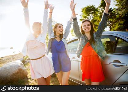 summer vacation, holidays, travel, road trip and people concept - happy teenage girls or young women near car at seaside