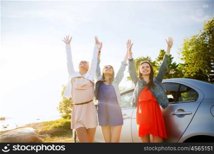 summer vacation, holidays, travel, road trip and people concept - happy teenage girls or young women near car at seaside