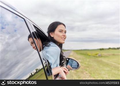 summer vacation, holidays, travel, road trip and people concept - happy young woman driving in car