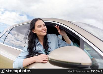 summer vacation, holidays, travel, road trip and people concept - happy young woman driving in car