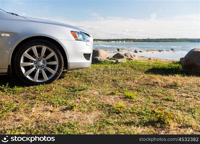 summer vacation, holidays, travel, road trip and transport concept - close up of car parked on sea shore or beach