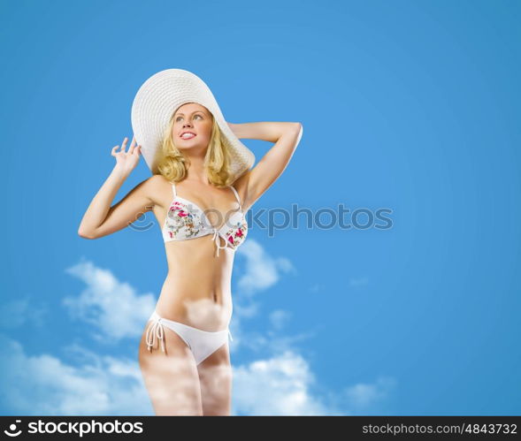 Summer vacation. Pretty girl in swimming suit and hat against color background