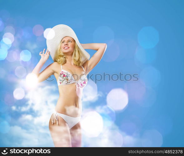 Summer vacation. Pretty girl in swimming suit and hat against color background