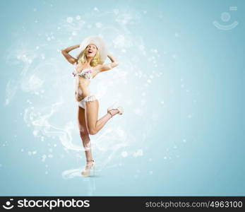 Summer vacation. Pretty girl in swimming suit and hat against color background