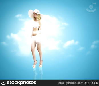 Summer vacation. Pretty girl in swimming suit and hat against color background