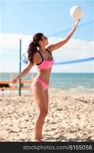 summer vacation, sport and people concept - young woman with ball playing volleyball on beach