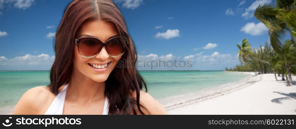 summer vacation, tourism, travel, holidays and people concept - face of smiling young woman with sunglasses over tropical beach with palms background