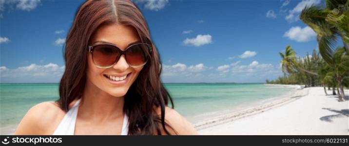 summer vacation, tourism, travel, holidays and people concept - face of smiling young woman with sunglasses over tropical beach with palms background