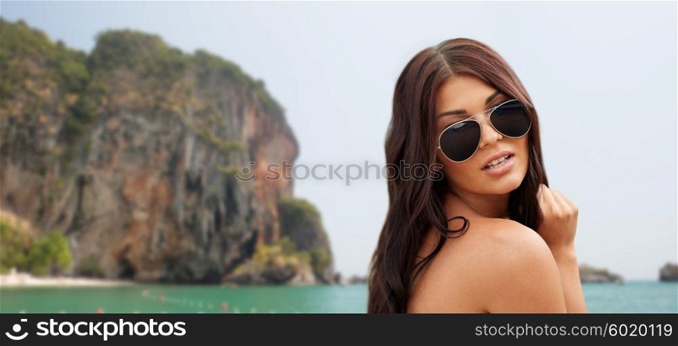 summer vacation, tourism, travel, holidays and people concept -face of young woman with sunglasses over rock on bali beach background