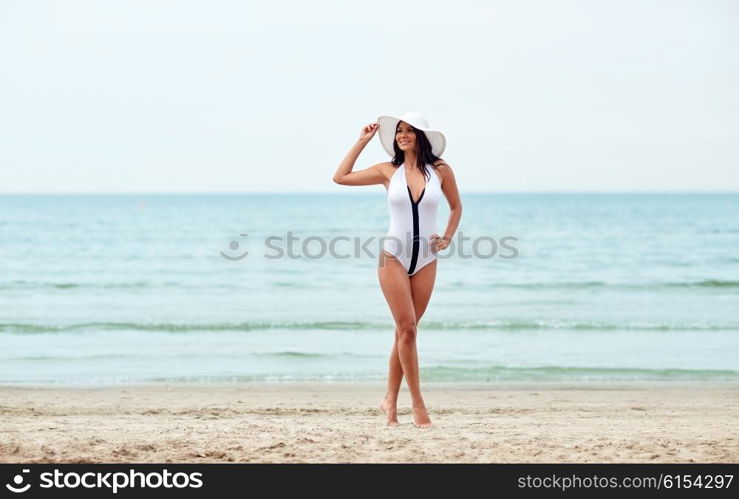 summer vacation, tourism, travel, holidays and people concept -young woman in swimsuit posing on beach