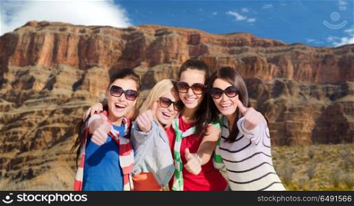 summer vacation, travel and tourism concept - beautiful teenage girls or young women showing thumbs up over rocks of grand canyon national park background. teenage girls or young women showing thumbs up. teenage girls or young women showing thumbs up