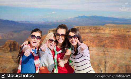 summer vacation, travel and tourism concept - beautiful teenage girls or young women showing thumbs up over rocks of grand canyon national park background. teenage girls or young women showing thumbs up. teenage girls or young women showing thumbs up