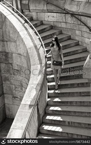 summer, vacation, travel, fashion and people concept - woman in sunglasses and dress walking down stairs with handbag