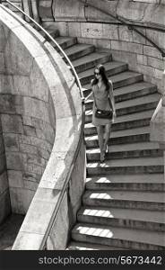 summer, vacation, travel, fashion and people concept - woman in sunglasses and dress walking down stairs with handbag