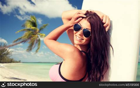 summer vacation, travel, surfing, water sport and people concept - young woman in swimsuit with surfboard on tropical beach