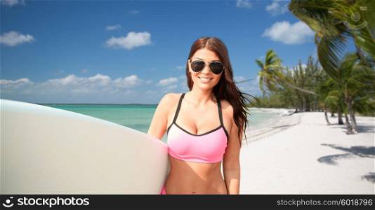 summer vacation, travel, surfing, water sport and people concept - young woman in swimsuit with surfboard over tropical beach with palms background