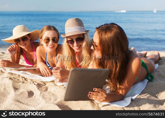 summer vacation, travel, technology and people concept - group of smiling women in sunglasses with tablet pc computers lying on beach