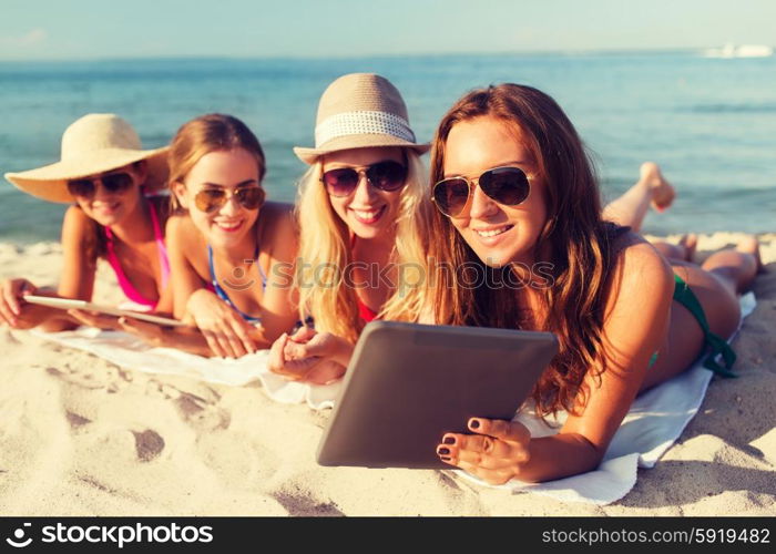 summer vacation, travel, technology and people concept - group of smiling women in sunglasses with tablet pc computers lying on beach