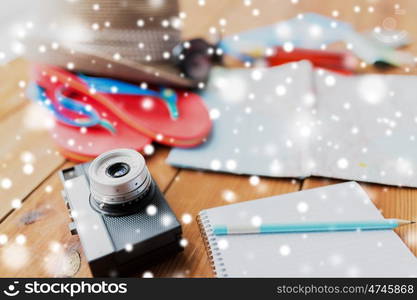 summer vacation, travel, tourism and objects concept - close up of camera, notepad with pencil and personal accessories