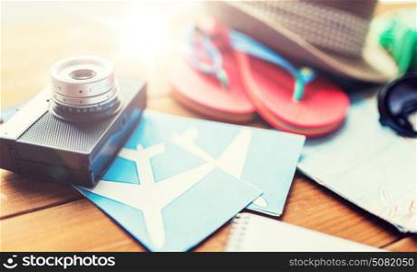 summer vacation, travel, tourism and objects concept - close up of camera, airplane tickets and personal accessories. close up of camera, tickets and travel stuff