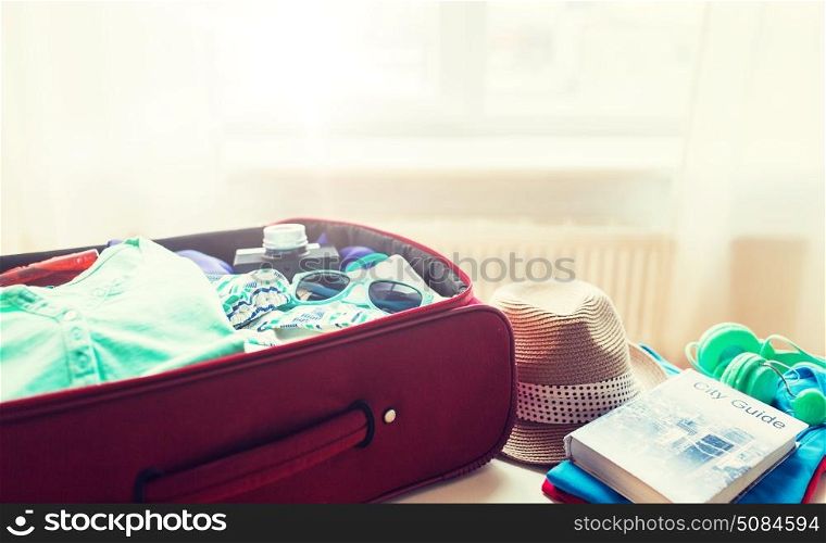summer vacation, travel, tourism and objects concept - close up of travel bag with clothes and stuff. close up of travel bag with clothes and stuff. close up of travel bag with clothes and stuff