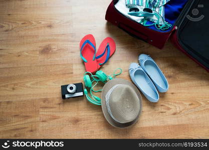 summer vacation, travel, tourism and objects concept - close up of travel bag with clothes and stuff