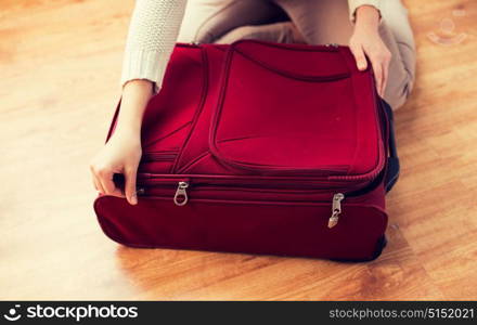 summer vacation, travel, tourism and objects concept - close up of woman packing and zipping travel bag for vacation. close up of woman packing travel bag for vacation