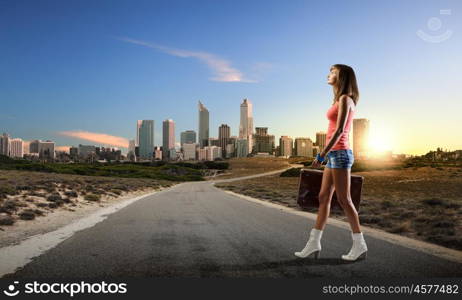 Summer vacation. Young pretty woman walking with suitcase in hand