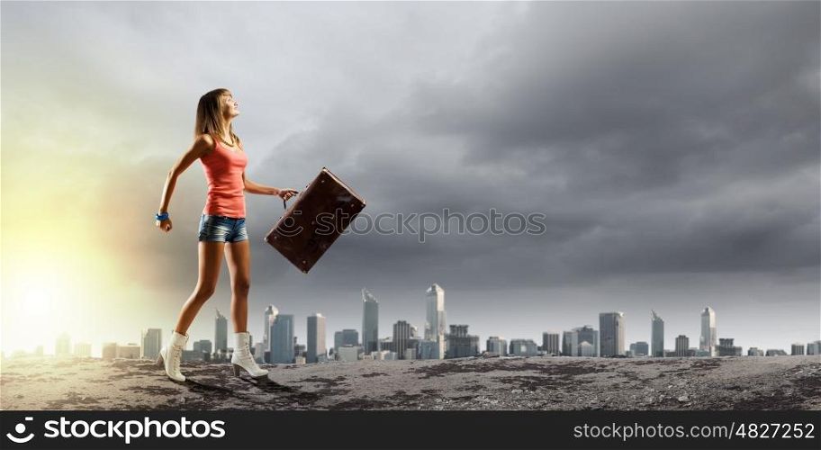 Summer vacation. Young pretty woman walking with suitcase in hand