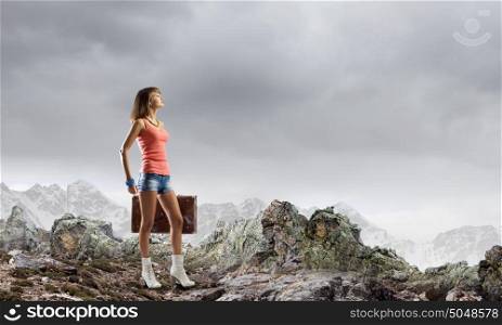 Summer vacation. Young pretty woman walking with suitcase in hand