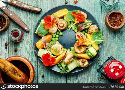 Summer vegetable salad decorated with nasturtium flowers. Summer vegetable salad with flowers.