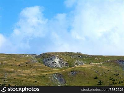 Summer view from Transalpina road (Southern Carpathians, Romania) with flock of sheep on slope.