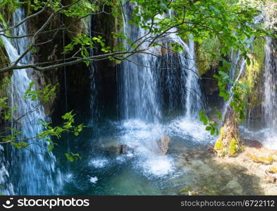 Summer view of beautiful waterfall and grotto (Plitvice Lakes National Park, Croatia)